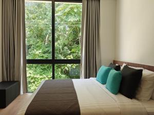 ein Schlafzimmer mit einem Bett mit einem großen Fenster in der Unterkunft Aileen Layan Villa 3 Private Pool 4 Bedroom in Layan Beach