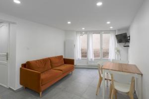 ein Wohnzimmer mit Sofa und Tisch in der Unterkunft Appartement dans maison atypique in Montrond-les-Bains