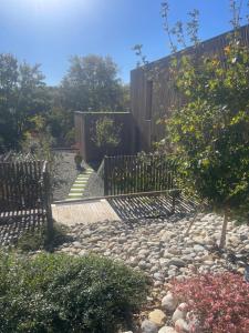 a garden with a fence and a stone walkway at Les Libellules in Gémil