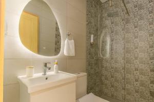 a bathroom with a sink and a toilet and a mirror at Cactus Apartment - Walk to Surf Beaches, Rooftop View, Remote Work, Free Parking, AC in Agadir nʼ Aït Sa
