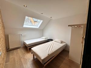 a small room with two beds and a window at Domaine de Hurlevent - Gite 10 personnes - Le Refuge in Aywaille