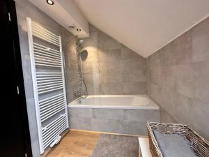 a bathroom with a bath tub in a room at Domaine de Hurlevent - Gite 10 personnes - Le Refuge in Aywaille