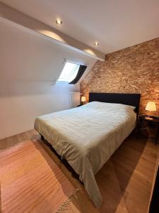 a bedroom with a bed and a stone wall at Domaine de Hurlevent - Gite 10 personnes - Le Refuge in Aywaille +10 photos