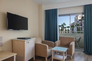 een woonkamer met een tv en een bank en stoelen bij Side Star Park Hotel - All Inclusive in Side