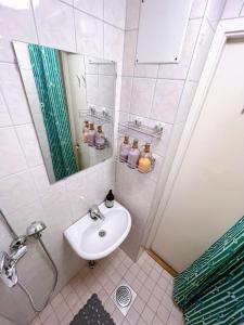 ein weißes Badezimmer mit Waschbecken und Spiegel in der Unterkunft Special price offer runs till 31st Dec 2025 in Helsinki