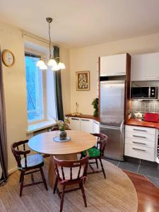 eine Küche mit Tisch und Stühlen und einem Kühlschrank in der Unterkunft Special price offer runs till 31st Dec 2025 in Helsinki