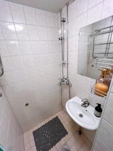 ein weißes Badezimmer mit Waschbecken und Spiegel in der Unterkunft Special price offer runs till 31st Dec 2025 in Helsinki + 1 Foto