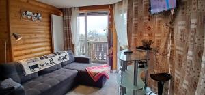 a living room with a couch and a window at Appartement les Coquelicots Super Besse in Besse-et-Saint-Anastaise