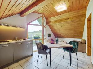 a kitchen with a table and chairs and a window at Weingut Schumann in Lieser +20 photos