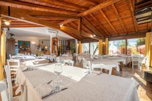 un restaurant avec des tables blanches et des chaises blanches dans l'établissement Hotel Montiruju, à Santa Maria