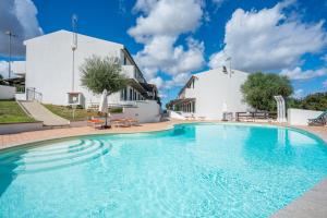 une grande piscine devant un bâtiment blanc dans l'établissement Hotel Montiruju, à Santa Maria