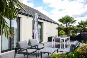 a patio with chairs and a table and an umbrella at FAA'mily Home, 3 bedrooms, meublé de tourisme 4 étoiles in Offemont