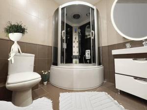 een badkamer met een douche, een toilet en een wastafel bij Мост сити АПП 75 ЛЮКС in Dnipro
