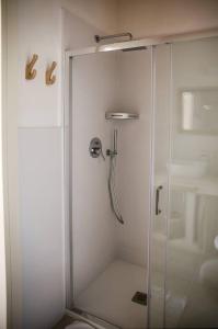 una doccia con una porta in vetro in un bagno di Masseria Voluzzi a Copertino