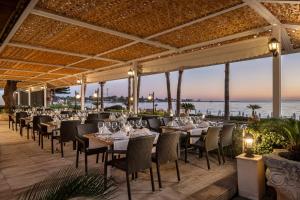een restaurant met tafels en stoelen met de oceaan op de achtergrond bij Side Star Park Hotel - All Inclusive in Side