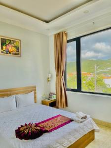 a bedroom with a bed and a large window at Chau Gia Hotel in Vĩnh Hy