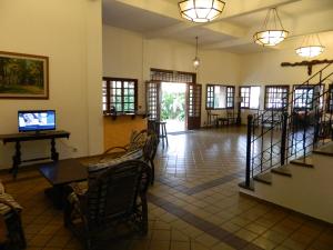 a lobby with a table and chairs and a television at Enseada Hotel in Ubatuba