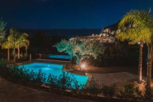 einen Swimmingpool mit Palmen in der Nacht in der Unterkunft Villa Teresa in Cefalú + 25 Fotos