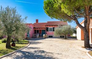 a pink house with trees in front of it at House Moreda by Istrialux in Vodnjan