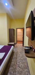 ein Schlafzimmer mit einem Bett und einem Schreibtisch mit einem Computer in der Unterkunft Hotel Sonali Golden Palace in Bhubaneshwar + 11 Fotos