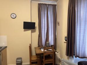 een kamer met een tafel en een klok op een raam bij Woodfield Lodge Apartments in Blackpool