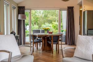 a dining room with a table and chairs and a large window at Charming Vacation Home Spier in Spier
