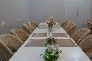 een lange tafel in een kamer met stoelen en bloemen bij Mahi Baagh Resort in Pāli