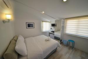 a white bedroom with a bed and a couch at Minu Hotel in Fethiye