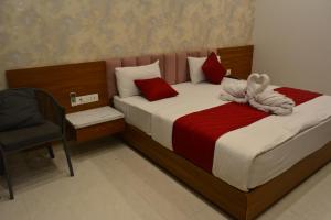 een slaapkamer met een groot bed met rode en witte kussens bij Mahi Baagh Resort in Pāli +5 foto's