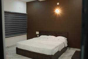 a bedroom with a bed with a light on the wall at Zeekka Tourist Home in Meenangadi