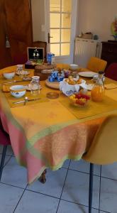 een tafel met een tafelkleed met voedsel erop bij Chambre D'hôtes De La Gandonnière in La Duchaie