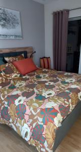 een bed in een slaapkamer met een kleurrijk dekbed bij Chambre D'hôtes De La Gandonnière in La Duchaie