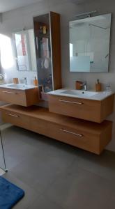 een badkamer met twee wastafels en een grote spiegel bij Chambre D'hôtes De La Gandonnière in La Duchaie