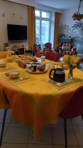 een tafel met een geel tafelkleed erop bij Chambre D'hôtes De La Gandonnière in La Duchaie