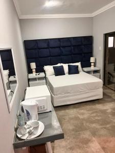 una camera da letto con un letto grande con testiera blu di Dzire Guesthouse a Thohoyandou Altre 9 foto