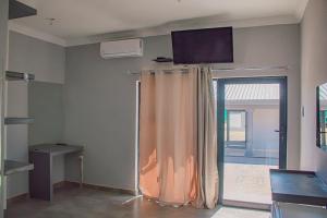 una stanza con tenda e televisore a parete di Dzire Guesthouse a Thohoyandou