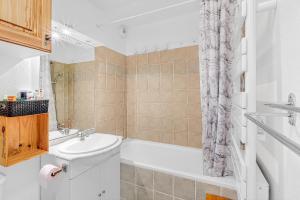 a bathroom with a sink and a tub and a toilet at appartement Superdevoluy in Superdevoluy