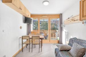 a living room with a table and chairs and a couch at appartement Superdevoluy in Superdevoluy