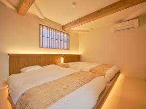 Postel nebo postele na pokoji v ubytování OKADOYA Osaka Kishinosato-tamade Sky Window SPA