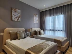 een hotelkamer met twee bedden en een raam bij WEG Title Legendary in Bang Tao Beach +20 foto's