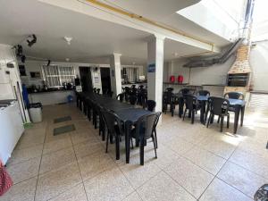 a dining room with black tables and chairs at Space Tour in Cabo Frio +11 photos