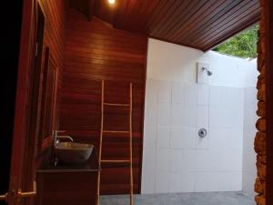 un bagno con lavandino e doccia di The Kudi a Nusa Lembongan