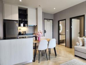 een keuken en woonkamer met een tafel en stoelen bij WEG Title Legendary in Bang Tao Beach