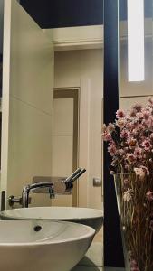 a bathroom with a sink and a mirror and flowers at Estilosa casa golf suites in Gorraiz +54 photos