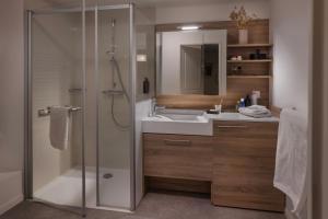een badkamer met douche, wastafel en spiegel bij DOMITYS - L'échiquier in Blois