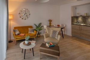 een woonkamer met twee stoelen en een tafel bij DOMITYS - L'échiquier in Blois