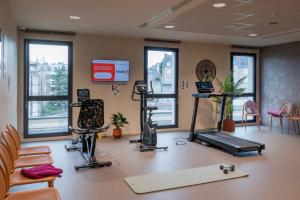 een fitnessruimte met loopbanden en fitnessapparatuur in een gebouw bij DOMITYS - L'échiquier in Blois