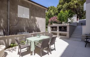 een terras met een tafel en stoelen en een gebouw bij Beautiful Apartment In Dingac With Wifi in Gornji Dingač