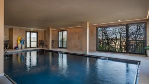 een groot zwembad in een huis met ramen bij DOMITYS - L'échiquier in Blois