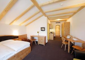 Col di VillaResidence Alpenrose的一间卧室，配有一张床、一张书桌和一张桌子